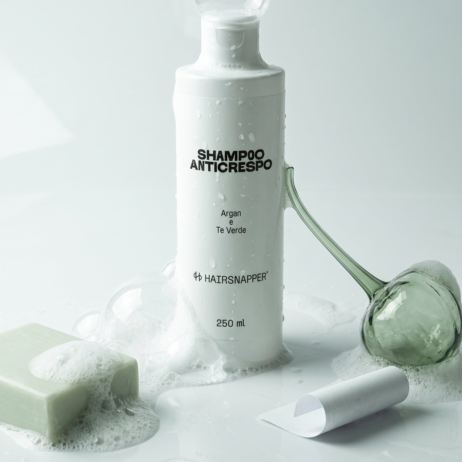 HairSnapper Shampoo Anticrespo 250 ml fra schiuma e bolle di sapone su fondo bianco