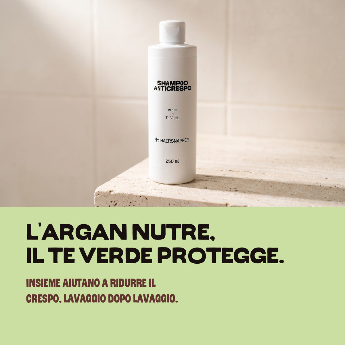 HairSnapper Shampoo Anticrespo su una mensola di travertino: l'argan nutre, il tè verde protegge