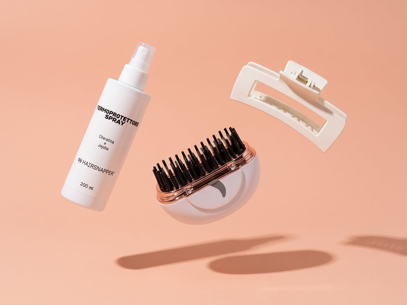 Touch Up Kit HairSnapper: Termoprotettore Spray, Brush e Clip sospesi su fondo pesca