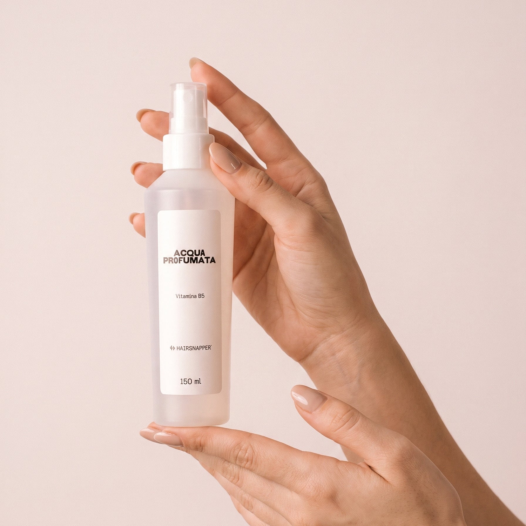 HairSnapper Acqua Profumata 150 ml tenuta fra due mani su fondo cipria