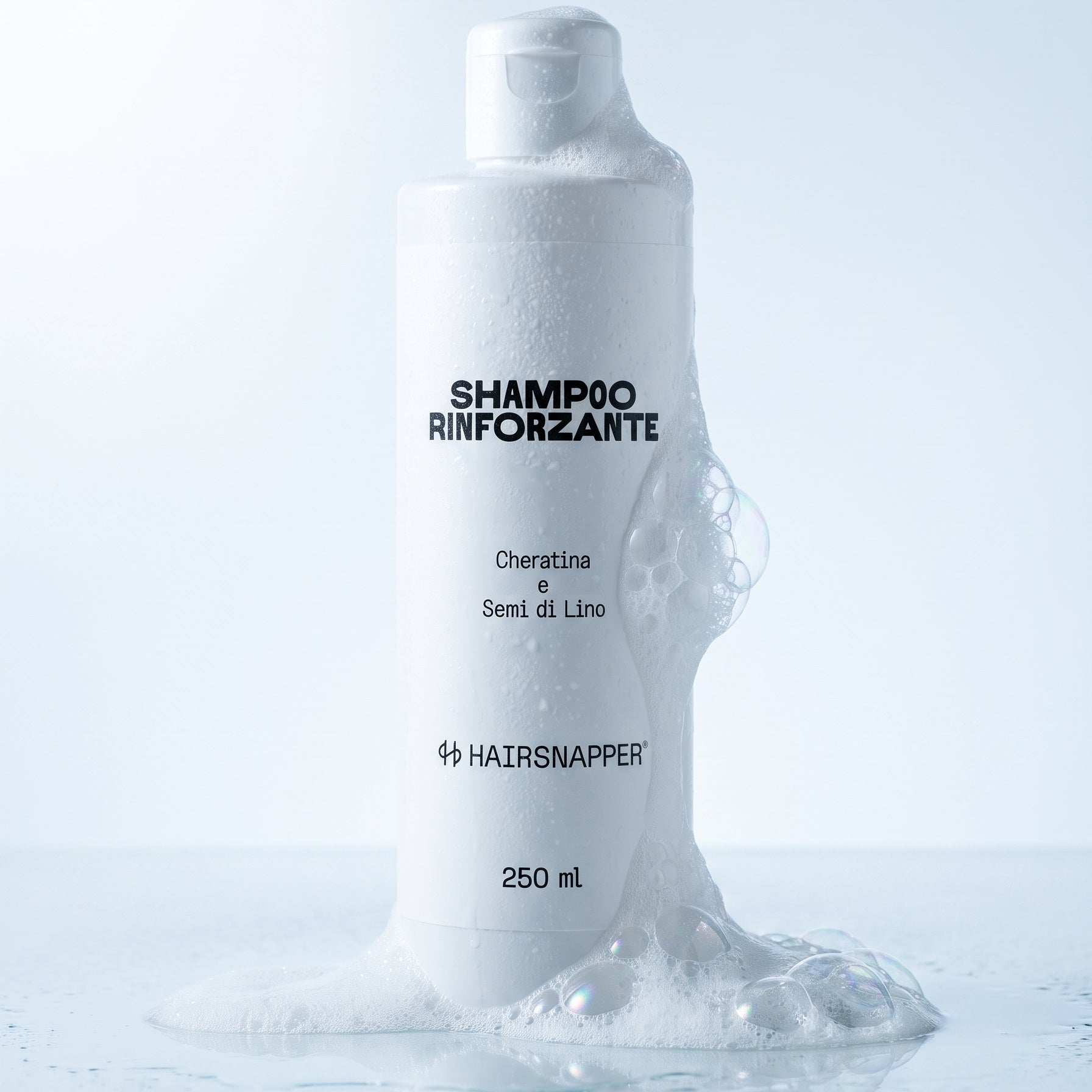 Il flacone HairSnapper Shampoo Rinforzante appoggiato in una pozza di schiuma