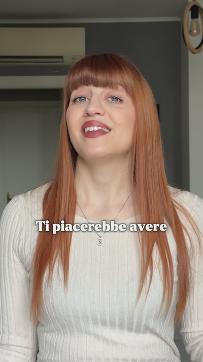 Una ragazza dai capelli rossi si sistema la piega davanti allo specchio con la HairSnapper Brush.