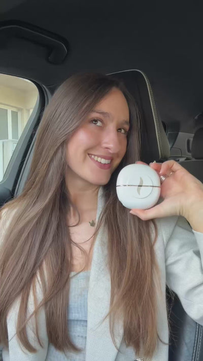 Una ragazza tira fuori la HairSnapper Brush dalla borsa e la passa sui capelli lunghi.